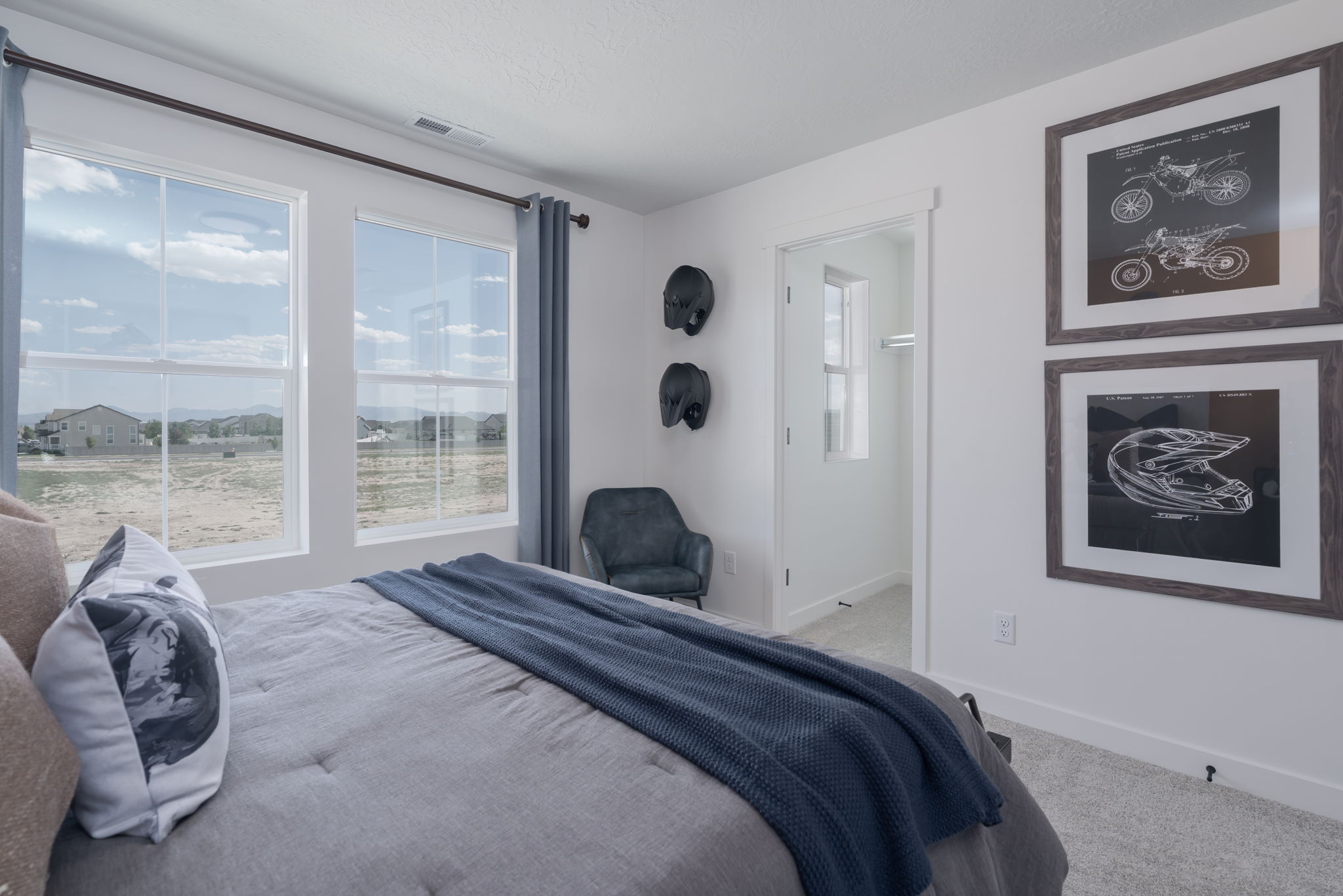 A bedroom with a bed and a chair.