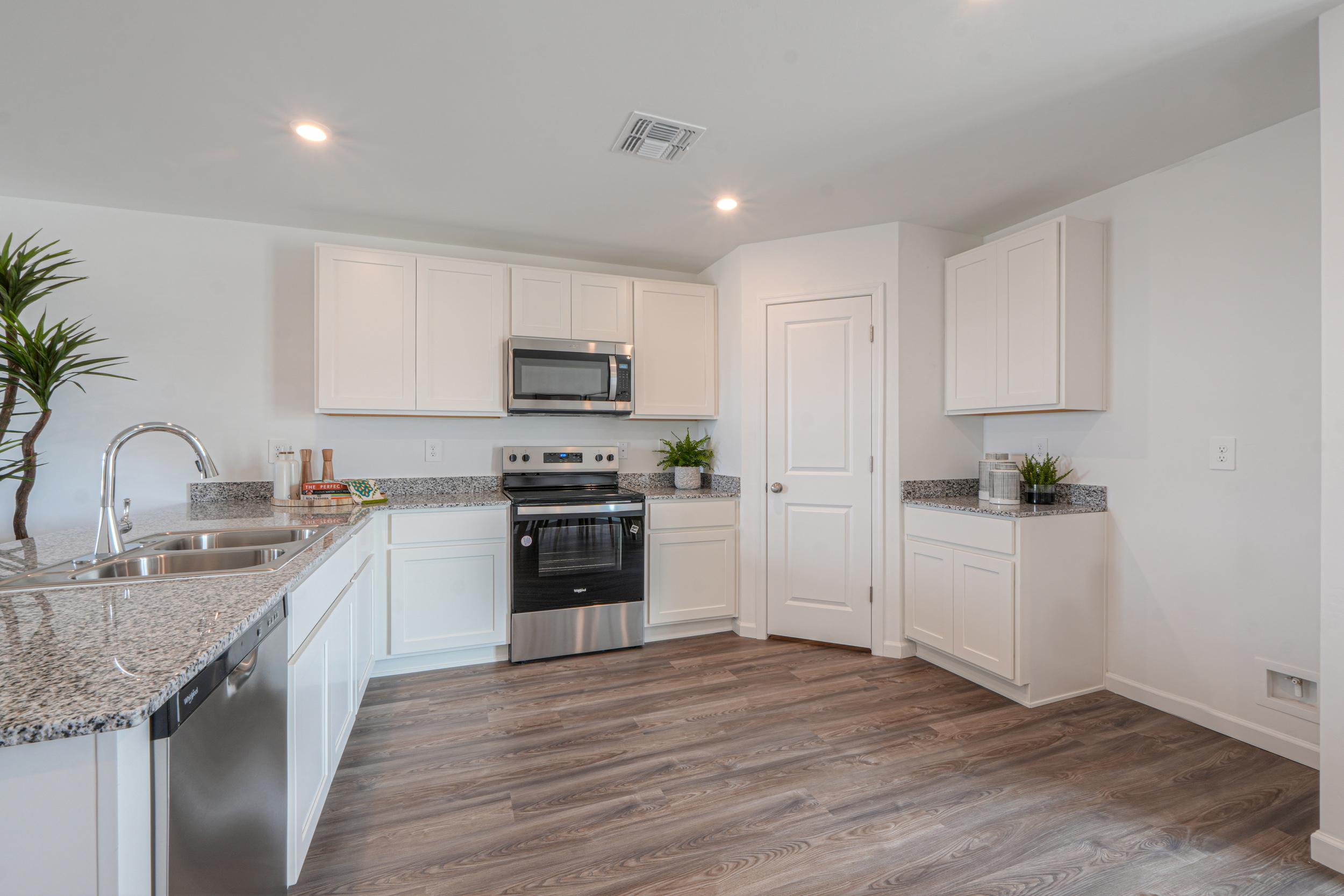 A kitchen with white cabinets.