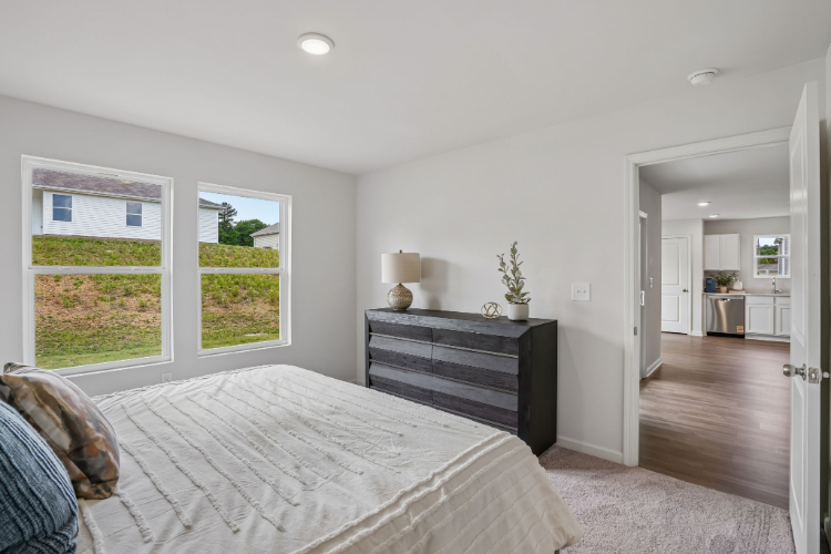 A bedroom with a bed and a dresser.