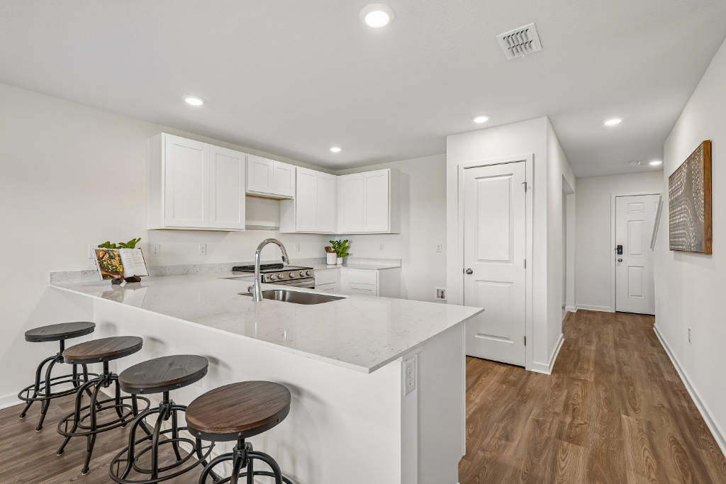 A kitchen with stools and a table.