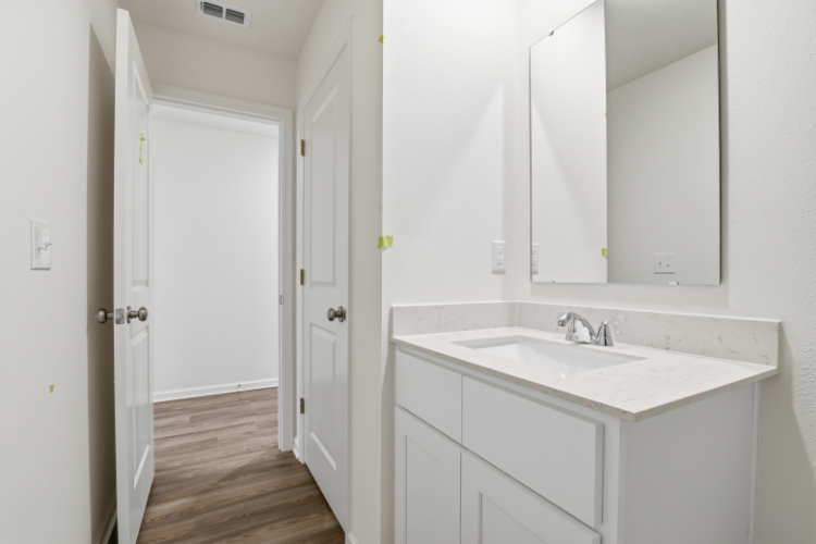 A bathroom with white cabinets.