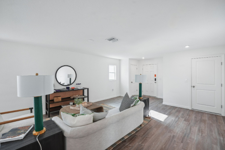 A living room with a couch and a mirror.