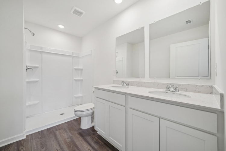 A bathroom with white cabinets.